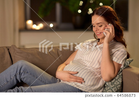 happy pregnant woman calling on smartphone at home happy pregnant woman calling on smartphone at home 64586873