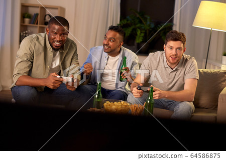 happy friends playing video games at home at night happy friends playing video games at home at night 64586875