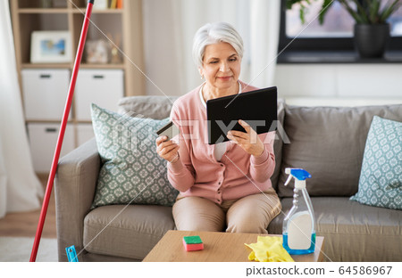 old woman with tablet pc and credit card at home old woman with tablet pc and credit card at home 64586967
