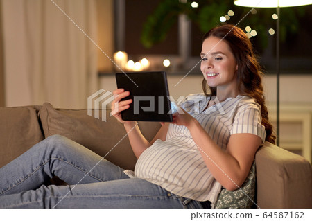 happy pregnant woman with tablet pc at home happy pregnant woman with tablet pc at home 64587162
