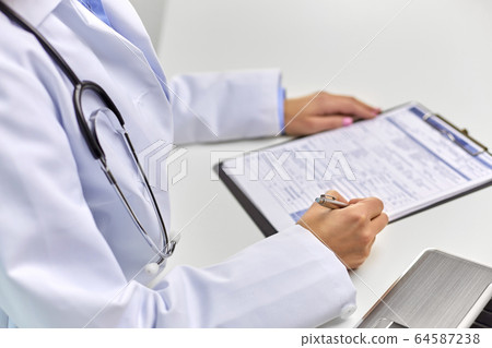 close up of female doctor writing medical report close up of female doctor writing medical report 64587238