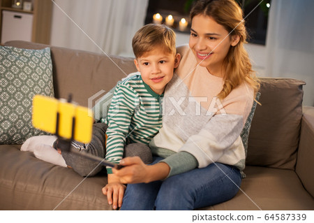 mother and son taking selfie by smartphone at home 64587339