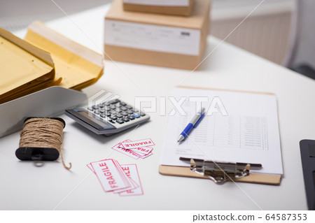 calculator, clipboard and envelopes at post office 64587353