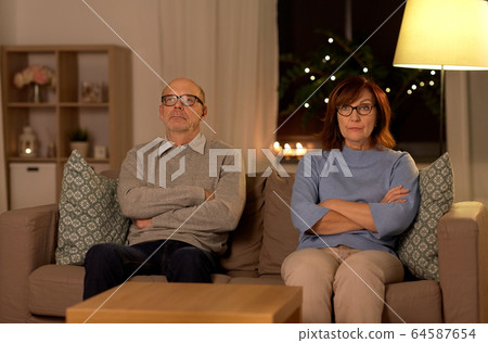 unhappy senior couple sitting on sofa at home unhappy senior couple sitting on sofa at home 64587654