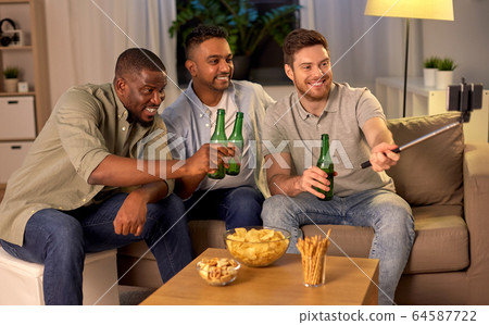 male friends with smartphone taking selfie at home 64587722