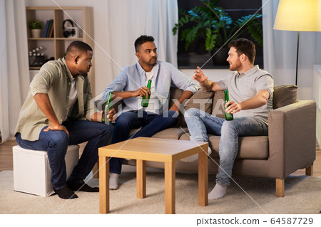 happy male friends drinking beer at home at night happy male friends drinking beer at home at night 64587729
