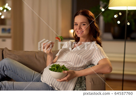 happy smiling pregnant woman eating salad at home happy smiling pregnant woman eating salad at home 64587760