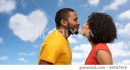 happy african american couple reaching for kiss 64587958