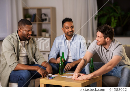happy male friends playing cards at home at night happy male friends playing cards at home at night 64588022