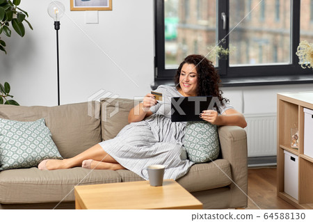 woman with tablet pc and credit card at home woman with tablet pc and credit card at home 64588130