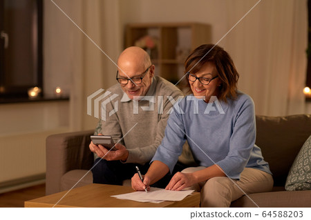 senior couple with papers and calculator at home senior couple with papers and calculator at home 64588203