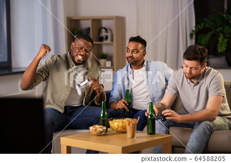happy friends playing video games at home at night happy friends playing video games at home at night 64588205