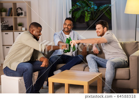 happy male friends drinking beer at home at night happy male friends drinking beer at home at night 64588318