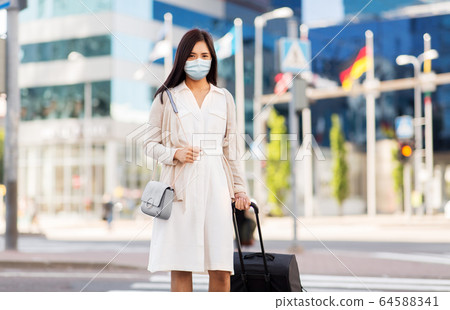 asian woman with travel bag in protective mask asian woman with travel bag in protective mask 64588341