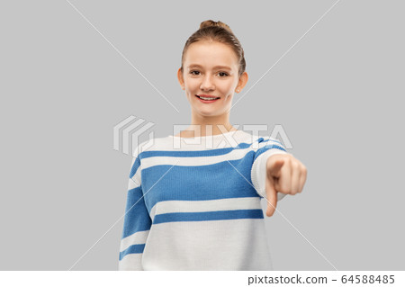 smiling teenage girl pointing to camera smiling teenage girl pointing to camera 64588485