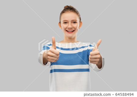smiling teenage girl showing thumbs up smiling teenage girl showing thumbs up 64588494