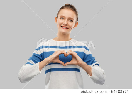 smiling teenage girl making hand heart smiling teenage girl making hand heart 64588575