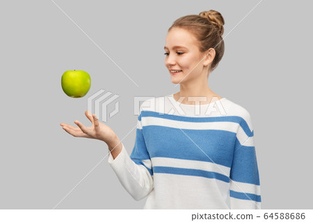 smiling teenage girl in pullover with green apple smiling teenage girl in pullover with green apple 64588686
