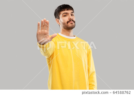 serious young man showing stop gesture serious young man showing stop gesture 64588762