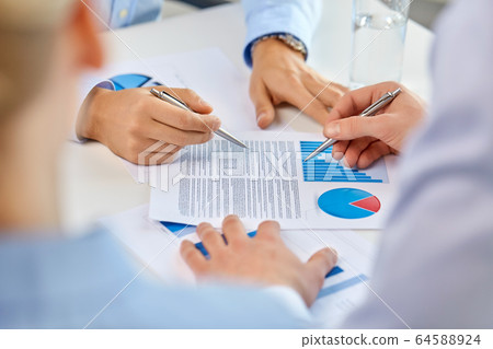 business team hands with pens and charts at office business team hands with pens and charts at office 64588924