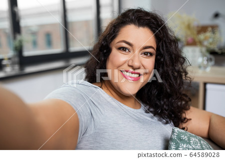 happy smiling young woman taking selfie at home happy smiling young woman taking selfie at home 64589028