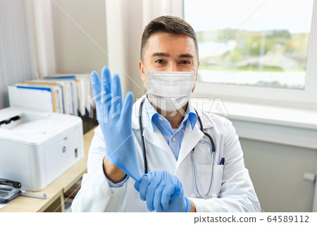 doctor in medical mask wearing gloves at hospital 64589112