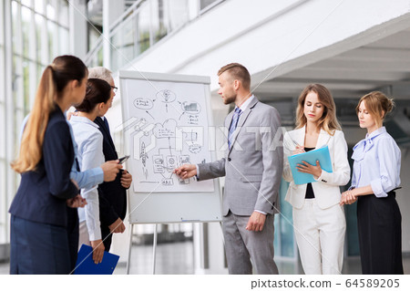business team with scheme on flip chart at office 64589205