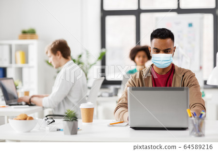 indian man with laptop in medical mask at office indian man with laptop in medical mask at office 64589216