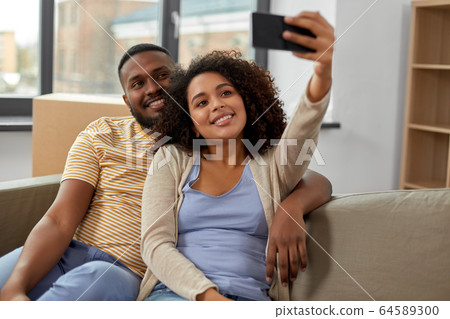 happy couple moving to new home and taking selfie happy couple moving to new home and taking selfie 64589300