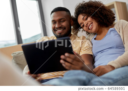happy couple with tablet pc computer at new home happy couple with tablet pc computer at new home 64589301