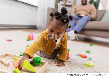 african baby girl playing with toy blocks at home african baby girl playing with toy blocks at home 64589304