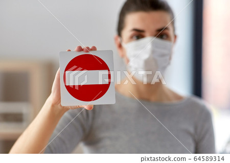 woman in protective medical mask showing stop sign woman in protective medical mask showing stop sign 64589314