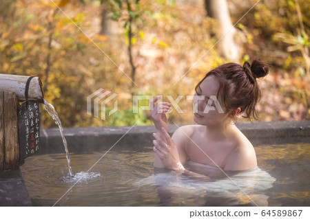 Woman enjoying a hot spring trip Woman enjoying a hot spring trip 64589867