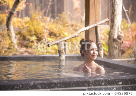 Woman enjoying a hot spring trip 64589875