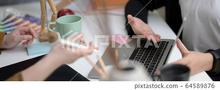 Cropped shot of designer team consulting on their 64589876