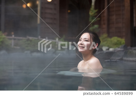 一個女人享受露天浴池 64589899