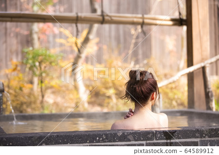 Woman enjoying a hot spring trip Woman enjoying a hot spring trip 64589912