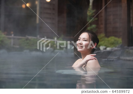 一個女人享受露天浴池 64589972