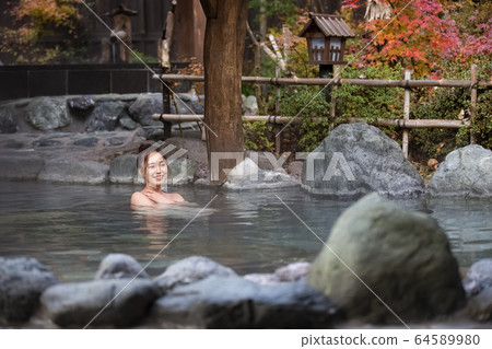 Woman enjoying a hot spring trip Woman enjoying a hot spring trip 64589980