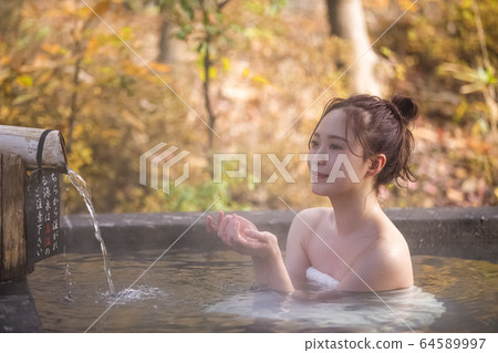 Woman enjoying a hot spring trip 64589997