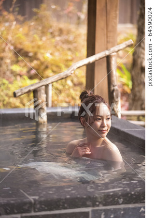 Woman enjoying a hot spring trip Woman enjoying a hot spring trip 64590024