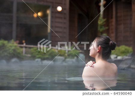 A woman enjoying an open-air bath A woman enjoying an open-air bath 64590040