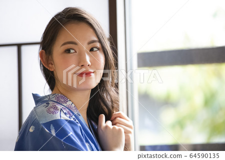 A woman getting dressed at an inn A woman getting dressed at an inn 64590135