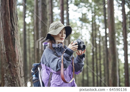 Woman taking pictures in the mountains Woman taking pictures in the mountains 64590136