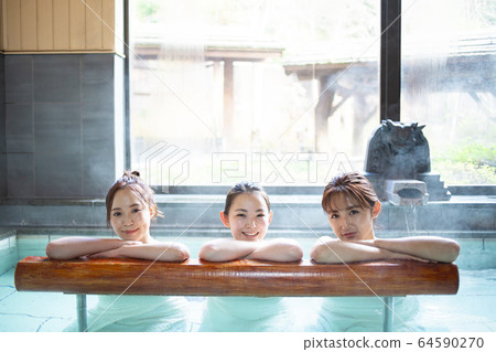 婦女和朋友享受露天浴池 婦女和朋友享受露天浴池 64590270