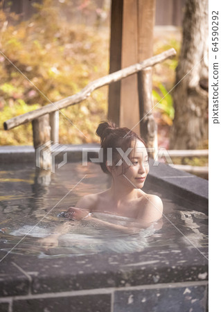 Woman enjoying a hot spring trip Woman enjoying a hot spring trip 64590292