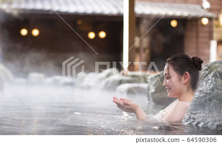 A woman enjoying an open-air bath A woman enjoying an open-air bath 64590306