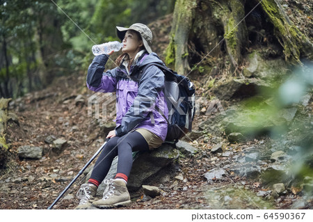 Woman taking a break in the mountains 64590367