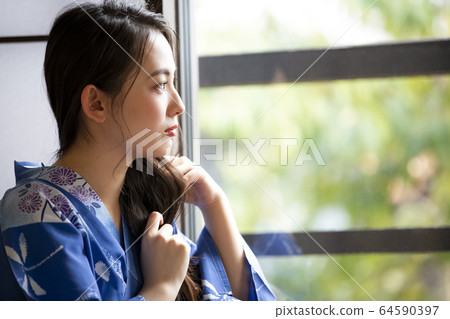 一個女人在一家旅館換衣服 一個女人在一家旅館換衣服 64590397