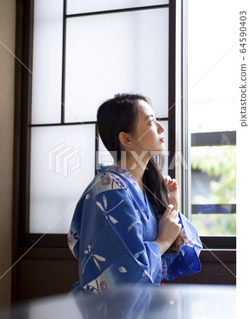 一個女人在一家旅館換衣服 一個女人在一家旅館換衣服 64590403